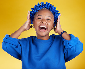 Image showing Portrait, queen and flower crown with an excited black woman in studio on a yellow background. Face, expression and sustainability with an attractive female wearing a blue wreath as royalty