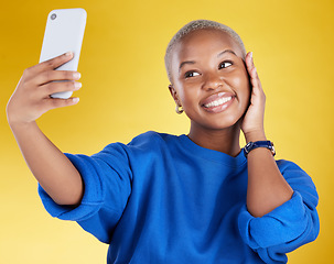 Image showing Smile, selfie and beauty of black woman in studio isolated on a yellow background. Photographer, social media and African female model taking pictures or photo for profile picture and happy memory.