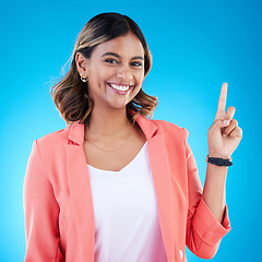 Image showing Smile, portrait and Indian woman in studio pointing up for product placement, mockup or information. Deal, promotion or announcement, happy model showing info space or notification on blue background