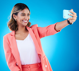 Image showing Selfie, smile and business woman in studio isolated on a blue background. Photographer, professional and Indian female entrepreneur taking photo for happy memory, social media and profile picture.