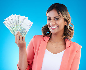 Image showing Portrait, smile and business woman with euros in studio isolated on a blue background. Financial winner, face and happy Indian female with cash money after winning lottery, prize and competition.