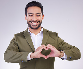 Image showing Hands, heart shape and business man portrait in studio for support, love and charity on a gray background. Asian entrepreneur person with hand emoji or icon for care, motivation and kindness smile