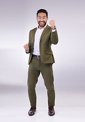 Image showing Business man, fist pump and celebrate success or winning portrait in studio on a gray background. Asian male entrepreneur with hands to cheer as winner for growth, bonus or finance profit achievement