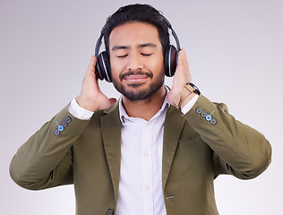 Image showing Music, relax and headphones with a business man in studio on a gray background streaming audio. Peace, quiet and calm with a male employee listening to the radio during a mental health break