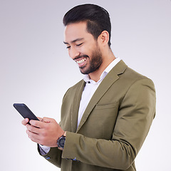 Image showing Business man, smile and phone for communication in studio while typing and networking on gray background. Asian male entrepreneur with smartphone for email, online chat or marketing on social media