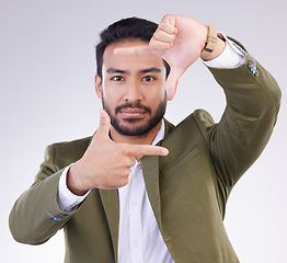 Image showing Finger framing, portrait and business man in studio, background or capture profile picture. Face of male model, hands and frame perspective for selfie, photography ideas or imagine border of planning