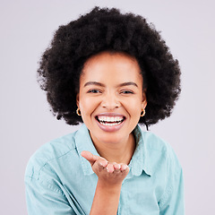 Image showing Happy, laughing and portrait of a black woman blowing kiss isolated on a white background in a studio. Laugh, smile and cheerful and beautiful African girl with a gesture for love, care and flirty