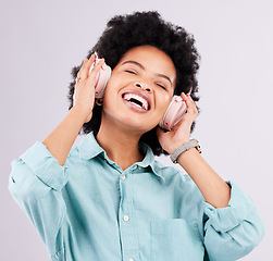 Image showing Music headphones, dance and happy black woman streaming song for studio fun, freedom and wellness. Dancing energy, audio podcast and person listening to radio, media sound or track on gray background