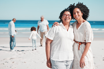 Image showing Portrait, summer with a mother and daughter on the beach during summer while their family play in the background. Love, smile or nature with a senior woman and adult child bonding outdoor together