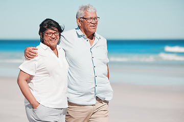 Image showing Senior couple walking on beach for love, care and relax on summer holiday in nature, sunshine or trust. Happy retirement, man and woman walk at sea, happiness and travel with partner, smile and ocean