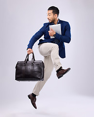 Image showing Late, work and an Asian man jump for business isolated on a white background in a studio. Fast, serious and a corporate Japanese businessman running in the air while rushing to the workplace