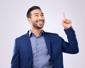 Image showing Asian man, business and pointing hand at space in studio for motivation and advertising. Happy model isolated on gray background as corporate professional and finger for mockup promotion announcement