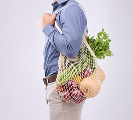 Image showing Diet, groceries and man with vegetables in studio for a healthy, vegan and wellness lifestyle. Health, nutrition and closeup of male model with bag of crops or food to cook dinner by gray background.