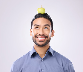 Image showing Apple, head balance and man happy with fruit product for weight loss diet, healthcare lifestyle or body detox. Wellness food, studio nutritionist person and male vegan isolated on gray background