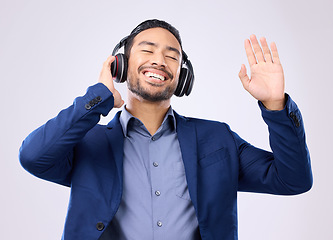 Image showing Business man, headphones and dancing on studio background for happiness, motivation and inspiration. Happy corporate worker, dance music and listening to radio sound, relaxing audio podcast and smile