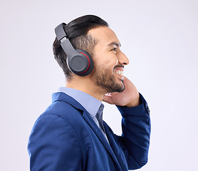 Image showing Business, happy man and thinking with music headphones, studio or background of happiness. Smile, young worker and listening to radio, sound and corporate podcast of audio, motivation and inspiration