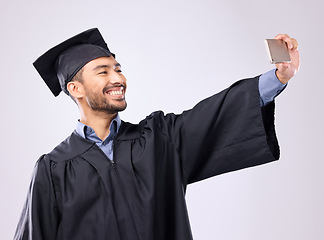 Image showing Man, graduate and selfie with smile for scholarship, profile picture or social media against a gray studio background. Happy excited male academic smiling for graduation photo, memory or online post