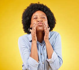 Image showing Happy, blow kiss and black woman in a studio for love, romance or flirting face gesture. Happiness, sensual and African female model with a romantic kissing facial expression by a yellow background.