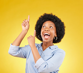 Image showing Studio promotion, excited and black woman point up at mock up space, advertising mockup or marketing promo. Commercial girl, gesture and happy person with product placement deal on yellow background