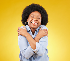 Image showing Black woman, happy with self love and hug body, smile and joy with eyes closed on yellow studio background. Female is cheerful, wellness and positive mindset with mockup space, happiness and selfcare