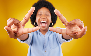 Image showing Happy, excited and black woman with a peace sign in studio with positive and goofy mindset. Happiness, smile and African female model with an afro posing with a v hand gesture by yellow background.