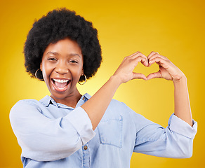 Image showing Love, heart hands and portrait of black woman, smile and kindness isolated on yellow background. Motivation, support and loving hand gesture, like sign or emoji, happy African model in studio mockup.