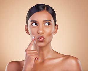 Image showing Indian woman, skincare and hand for thinking in studio with face, beauty and pouting by background. Young asian model, gen z girl and cosmetics for natural skin glow, aesthetic or happiness for idea