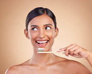 Image showing Woman, thinking and bamboo toothbrush for dental care, teeth or healthcare and skincare against a studio background. Happy female smile with tooth paste for healthy clean oral, mouth or gum hygiene