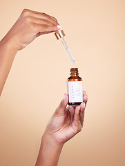 Image showing Hands, serum and pipette with bottle product in studio isolated on brown background. Skincare, dermatology and woman model with cruelty free hyaluronic acid, vegan retinol or essential oil cosmetics.