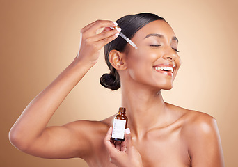 Image showing Woman, dropper and retinol on face for skincare beauty or cosmetics against a studio background. Happy beautiful female model applying oil drop to skin for hydration, moisturizer or facial treatment