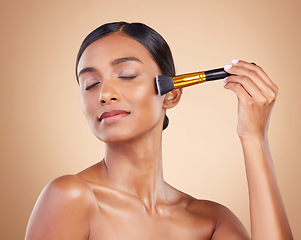Image showing Woman, brush or makeup artist with beauty, cosmetic products or self care in studio background. Eyes closed, model face or relaxed young Indian girl with cosmetics, glowing skincare or application