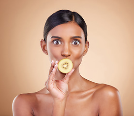 Image showing Wow, beauty or woman with kiwi for healthy detox, skincare or facial treatment routine in headshot. Food nutrition, face or crazy Indian girl with wellness or fruits isolated on studio background