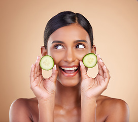 Image showing Woman, thinking and cucumber for natural skincare, beauty and nutrition cosmetics against a studio background. Happy female holding vegetables in thought for healthy organic diet or facial treatment