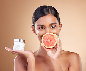 Image showing Grapefruit, portrait or happy woman with cream product for face beauty or skincare isolated on studio background. Cosmetics glow, smile or Indian girl with facial moisturizer or dermatology lotion