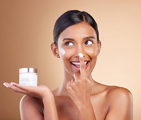 Image showing Woman, face and applying moisturizer cream for beauty skincare cosmetics, self love or care against a studio background. Happy female with smile for lotion, moisturizing creme or facial treatment