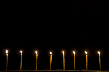 Image showing 8 candles in the dark