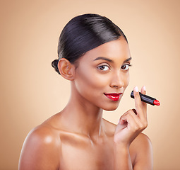 Image showing Portrait, skincare and Indian woman with lipstick, beauty and happy against brown studio background. Face, female and lady with makeup, cosmetics and red gloss with confidence, aesthetic and glowing