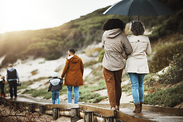 Image showing Back, nature and a family walking on a wooden path outdoor together for holiday or vacation. Love, environment and bonding with relatives taking a walk near the beach while bonding in winter