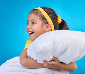 Image showing Happy, cute and child with a pillow for sleep isolated on a blue background in a studio. Smile, excited and a young little girl thinking of sleeping, getting ready for a nap or rest on a backdrop