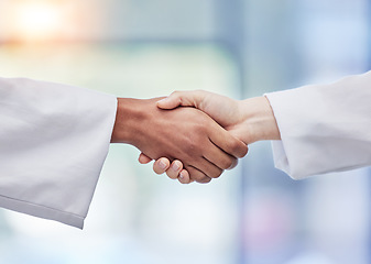 Image showing Doctors, handshake and healthcare partnership in agreement, teamwork deal or collaboration. Medical professionals shaking hands in meeting, greeting and success of trust, thank you or consulting help