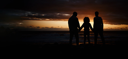 Image showing Beach, sunset and silhouette of a family holding hands in the dark while on summer vacation or trip. Adventure, love and shadow of people in nature by ocean together while on seaside travel holiday.