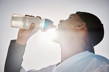 Image showing Baseball player, drinking water or thirsty sports man on field in training match or game in a stadium. Sunshine, cardio fitness workout or healthy softball athlete drinks liquid for energy in summer