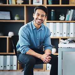 Image showing Relax, break and portrait of businessman smile and sitting in startup company office excited for the future. Young, happy and professional man employee or worker feeling confident, proud