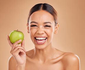 Image showing Portrait, beauty and woman with skincare, apple and smile with girl against brown studio background. Portrait, female and lady with fruit, diet and cosmetics with happiness, healthy lifestyle or joy