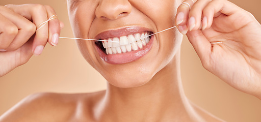 Image showing Flossing, smile and a woman with dental care for teeth isolated on a studio background. Happy, healthcare and the mouth of a girl with a routine oral hygiene cleaning, treatment and tooth floss