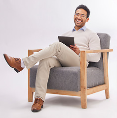 Image showing Business man on armchair isolated on a white background happy therapist portrait, career mindset and work on tablet. Asian professional person or psychologist relax on chair, digital tech and studio