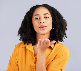 Image showing Flirty, happy and a portrait of a woman blowing kiss isolated on a studio background. Love, smile and a flirtatious girl with a loving, cute and romantic gesture on a backdrop for expression