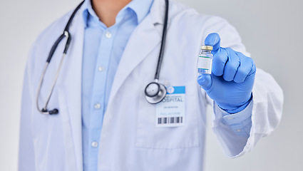 Image showing Vaccine vial, doctor and hands in studio for safety, healthcare and pharmaceutical medicine. Closeup, vaccination and bottle for virus immunity, medical antibiotics and wellness drugs on background