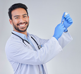 Image showing Covid, vaccine and portrait of doctor in studio, happy and smile for medicine, breakthrough or cure on grey background. Medical, innovation and face of male corona expert with futuristic treatment