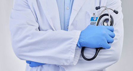 Image showing Arms crossed, closeup doctor and stethoscope in studio for medicine, medical services and wellness consulting. Healthcare worker, zoom and professional cardiology on background for heart consultation